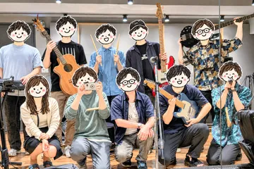 スタジオでギターやドラムのスティックを手に並ぶ、イベントの参加者